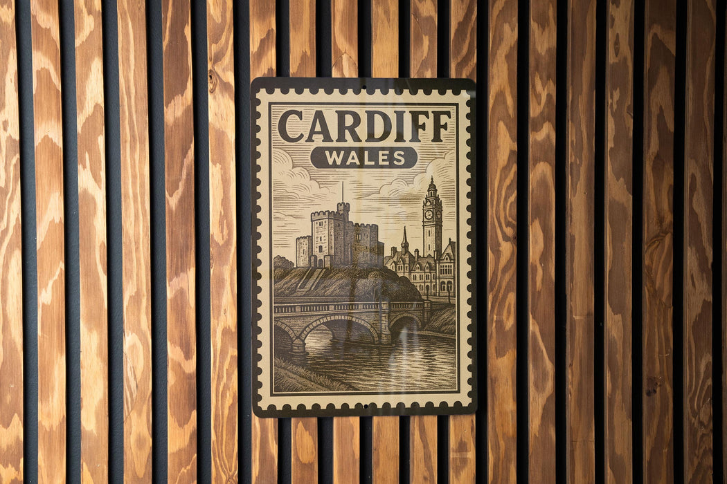 A vintage-style poster of Cardiff, Wales, featuring a castle and a bridge, is displayed on a wooden wall.