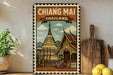 A vintage-style poster of the Chiang Mai temple in Thailand, featuring a golden temple with a spire and a wooden roof, surrounded by lush greenery.