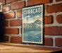 A vintage-style postage stamp featuring the city of Curacao, with a brick wall and wooden table in the background.
