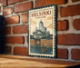 A vintage-style metal sign with the text "HELSINKI FINLAND" and an illustration of the Helsinki Cathedral, a famous landmark in Finland.