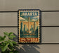 A vintage-style poster of Jakarta, Indonesia, featuring a cityscape with a tall tower, is displayed on a wall.