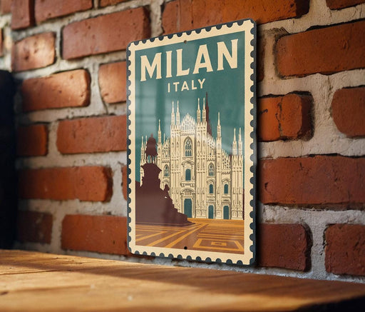 A vintage-style poster of Milan, Italy, featuring the iconic Duomo di Milano cathedral, is displayed on a brick wall.