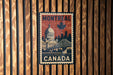 A vintage-style metal stamp depicting the city of Montreal, Canada, with a large dome building and a bridge in the background.
