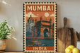 a vintage-style poster of Mumbai, India, with a boat and a building depicted on the poster. The poster is framed and displayed on a wall, with a wooden cutting board and a potted plant to the side.