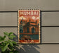 A vintage-style poster of Mumbai, India, featuring the Gateway of India and a boat, is displayed on a wall.