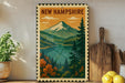 A framed vintage postcard depicting a scenic mountain landscape with a lake, surrounded by pine trees and autumn foliage, is displayed on a shelf next to a wooden cutting board and a potted plant.