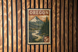 A vintage-style postage stamp from Oregon featuring a mountain landscape with a winding river.