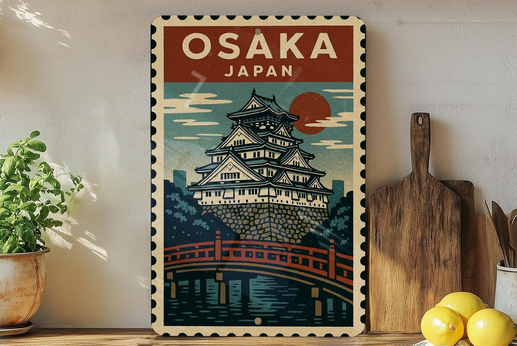 A framed poster of Osaka, Japan, featuring a traditional Japanese castle or pagoda with a bridge in the background.