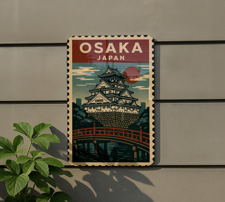 A vintage-style poster of Osaka, Japan, featuring a castle-like structure and a bridge, is displayed on a wall.