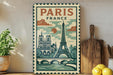 a vintage-style poster of Paris, France, with the Eiffel Tower and other iconic landmarks depicted. The poster is displayed on a wall, with a wooden cutting board and a potted plant to the left, and a bowl of lemons to the right.