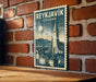A vintage-style metal stamp depicting Reykjavik, Iceland, with a castle and town in the background.
