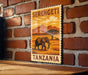 A vintage-style stamp or postcard with an illustration of an elephant in a grassy field, mounted on a brick wall.