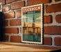 A vintage-style poster of Stockholm, Sweden, featuring a cityscape with a church spire and a bridge, is displayed on a brick wall.