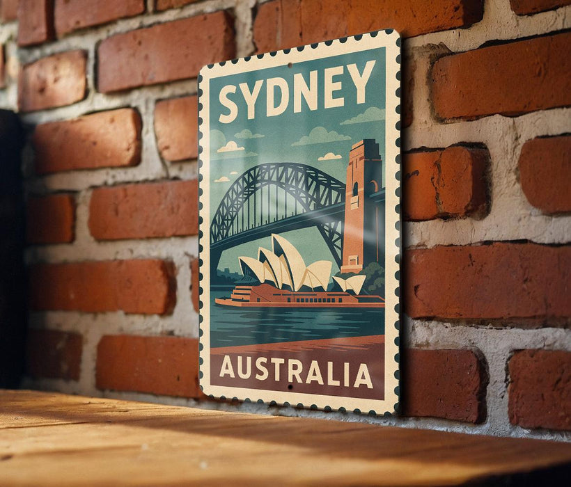 A vintage-style poster of Sydney, Australia, featuring the iconic Sydney Opera House and the Sydney Harbour Bridge, is displayed on a brick wall.
