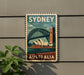 A vintage-style poster of Sydney, Australia, featuring the iconic Sydney Harbour Bridge and the Sydney Opera House, is displayed on a wall.
