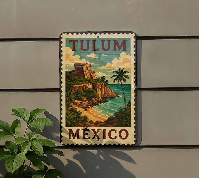 A vintage-style metal sign with the text "TULUM MEXICO" and an illustration of a tropical beach and cliff, mounted on a wall.