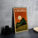 A vintage-style metal sign with the word "VIRGINIA" prominently displayed, featuring a landscape with a sunset and mountains in the background.