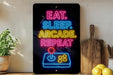 A neon sign with the text "EAT. SLEEP. arcADE. repeat" is displayed on a wall, with a wooden cutting board and a potted plant to the side.