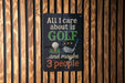 A sign with the text "ALL I care about is GOLF...and maybe 3 people" is displayed on a wooden wall.