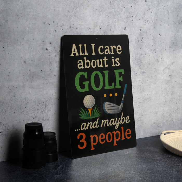 A humorous sign that reads "ALL I care about is GOLF and maybe 3 people" is displayed on a table next to some black camera lenses.