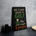 A humorous sign that reads "ALL I care about is GOLF and maybe 3 people" is displayed on a table next to some black camera lenses.