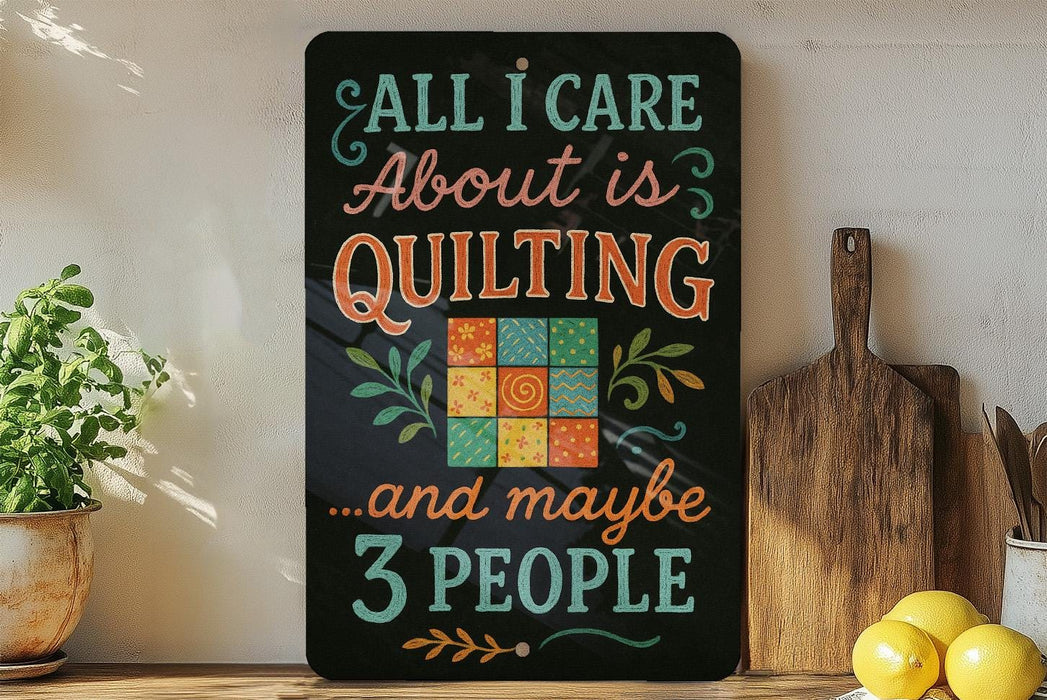 a black sign with colorful text and a quilt design, placed on a wooden surface next to a cutting board and some kitchen utensils.