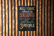a sign with the text "All I care about is skiing...and maybe 3 people" displayed on a wooden wall.