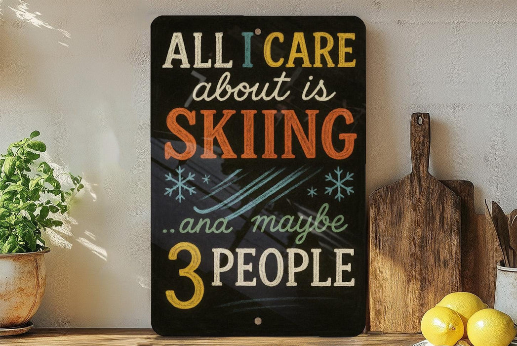 A black sign with colorful text that reads "ALL I CARE about is SKIING...and maybe 3 people" is displayed on a wooden shelf next to a wooden cutting board and a potted plant.