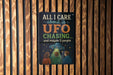 a sign with the text "All I care about is UFO chasing... and maybe 3 people" displayed on a wooden wall.
