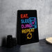 A neon sign with the text "EAT. SLEEP. DJING. REPEAT" is displayed on a black surface, accompanied by a stack of black camera lenses.