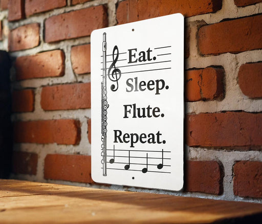 A sign with musical notes and a flute on a brick wall.