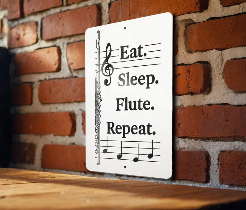 A sign with musical notes and a flute on a brick wall.