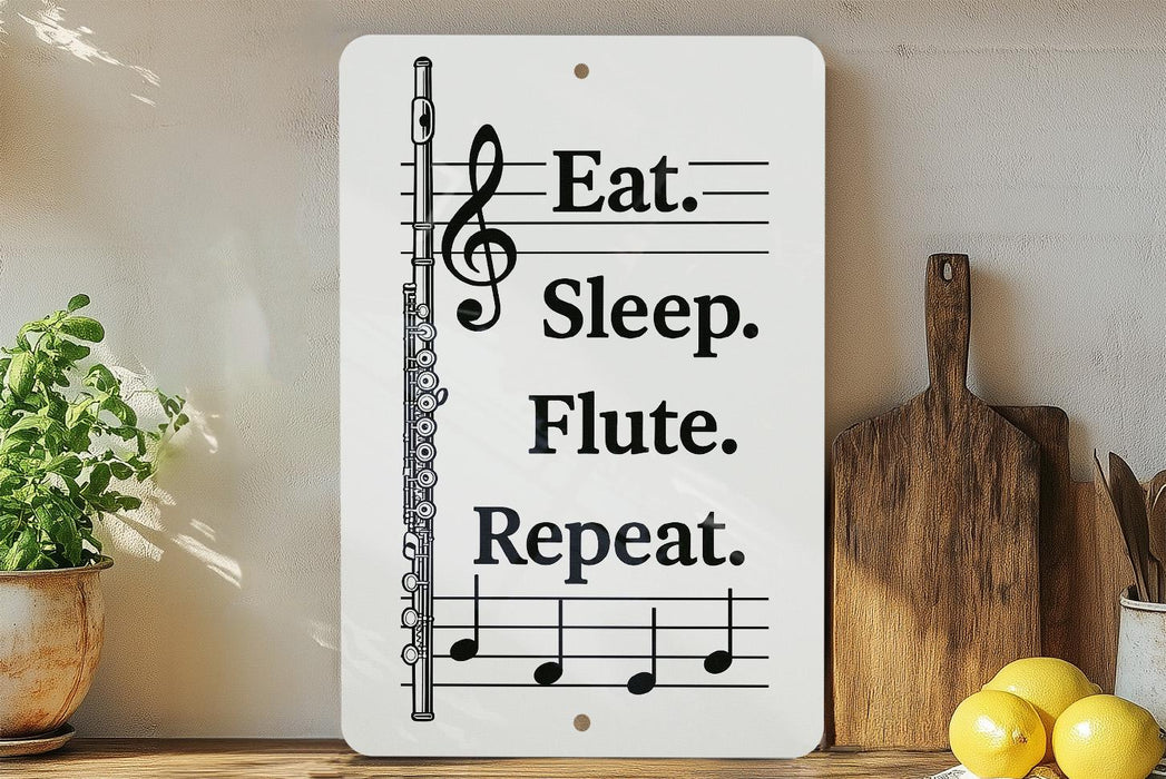 a white sign with black text and musical notes, placed on a wooden surface next to a potted plant and a wooden cutting board.