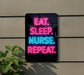 a neon sign with the message "EAT. SLEEP. NURSE. REPEAT." displayed on a wall.