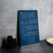a blue sign with white text that reads "EAT. SLEEP. PUZZLES. REPEAT." The sign is placed on a gray countertop next to a stack of black cups and a white bowl.