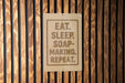 a sign with the text "EAT. SLEEP. SOAP-MAKING. REPEAT."