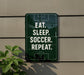 a sign with the message "EAT. SLEEP. SOCCER. REPEAT." displayed on a wall.