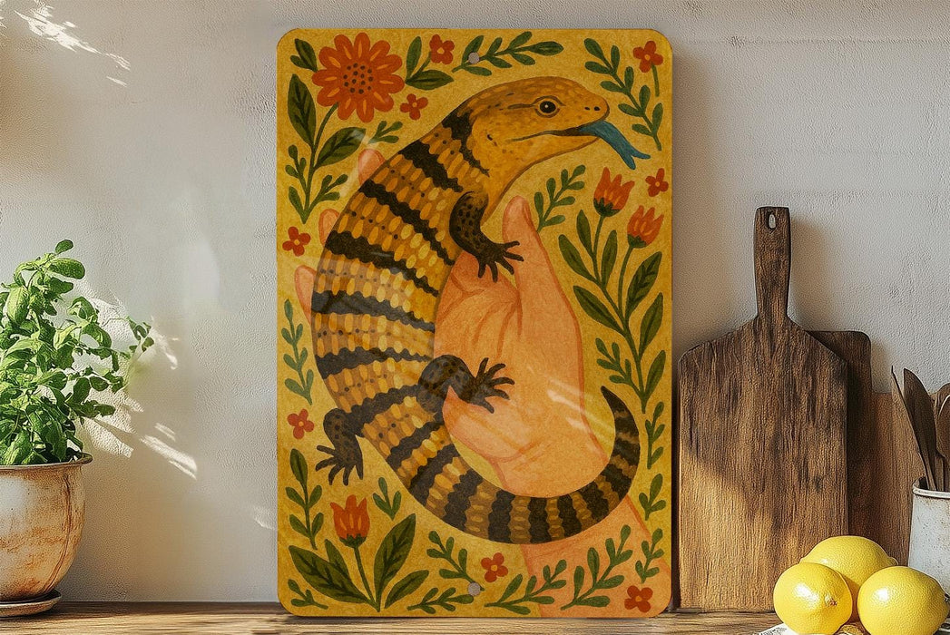 a vibrant, hand-painted illustration of a colorful lizard or salamander, surrounded by a lush floral border, placed on a wooden surface.