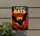 A sign with the text "A COLONY OF BAT" and an illustration of bats against a sunset background.