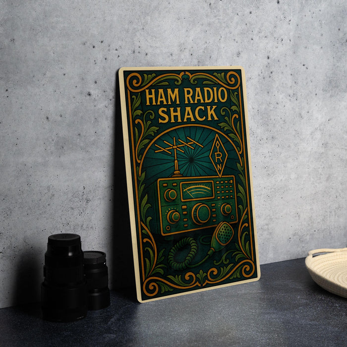 A vintage-style metal sign for Ham Radio Shack, featuring an antenna and radio equipment, is displayed on a gray countertop next to a stack of black camera lenses.