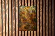 A stained glass artwork depicting a group of foxes in a natural landscape, with a wolf howling in the background.