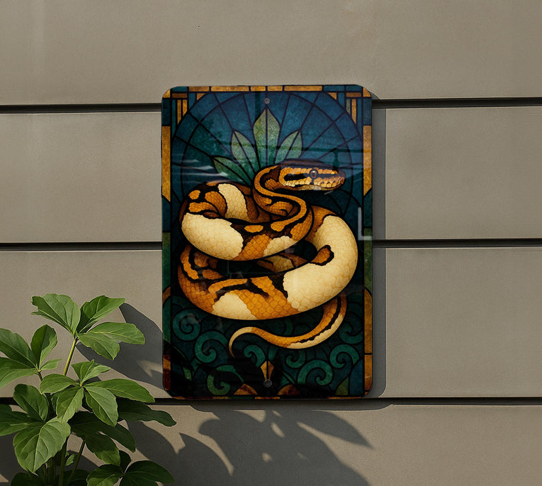 a colorful painting of a snake on a wall, with a plant in the foreground.