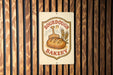 a sign for a bakery, with a wooden background and a bread loaf illustration.
