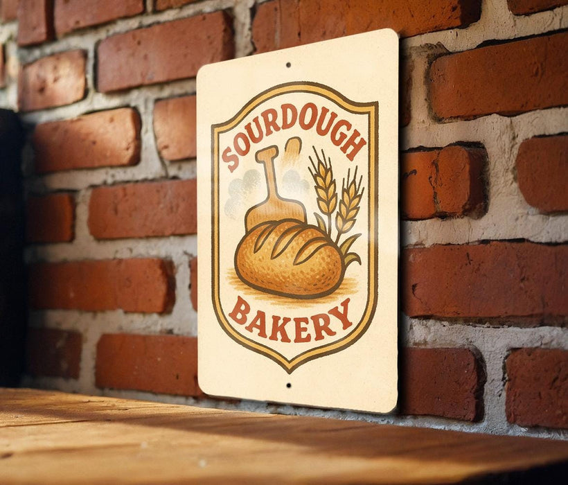 A sign for a bakery called "Sour Dough Bakery" is displayed on a brick wall.