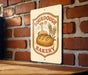 A sign for a bakery called "Sour Dough Bakery" is displayed on a brick wall.