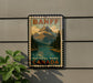 A vintage-style sign for Banff National Park, featuring a mountain landscape with a lake and pine trees, mounted on a wall.