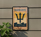 A vintage-style sign with the word "BARBADOS" and a trident symbol is displayed on a wall, with a plant to the left.