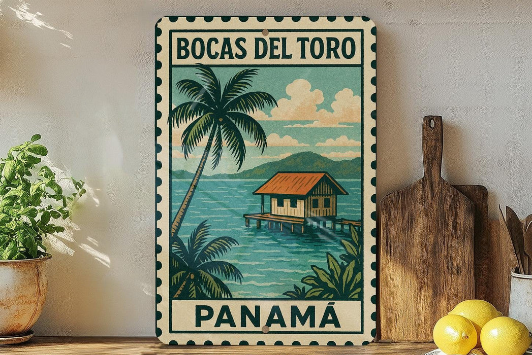 A vintage-style metal sign with a tropical island scene, featuring a wooden hut, palm trees, and a body of water. The sign is framed with a border and displays the text "BOCAS DEL TORO PANAMA".