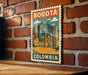 A vintage-style poster of Bogota, Colombia, featuring a cityscape with buildings and a mountain in the background.