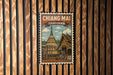 A vintage-style poster of the Chiang Mai temple in Thailand, featuring a colorful illustration of the temple and surrounding landscape.